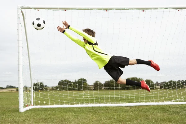 Pojke målvakt hoppning — Stockfoto