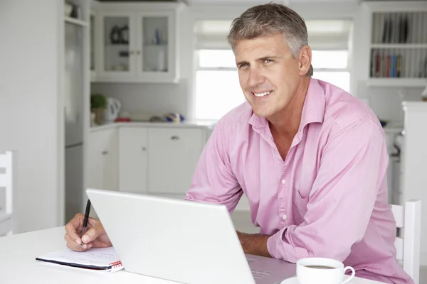 Hombre de mediana edad trabajando en el ordenador portátil — Foto de Stock