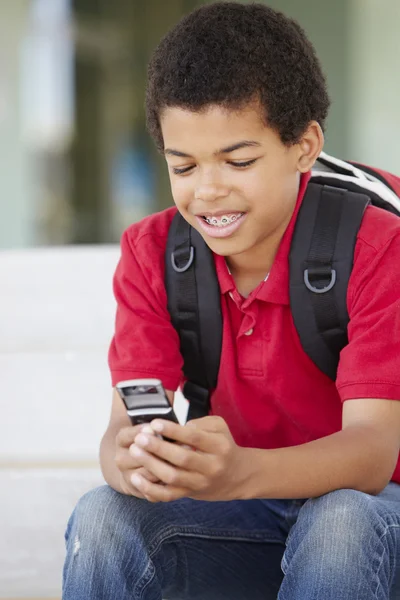 Мальчик с телефоном в школе — стоковое фото