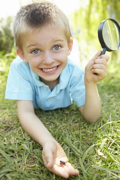 Giovane ragazzo con lente d'ingrandimento — Foto Stock