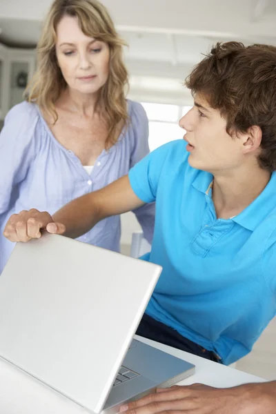 Madre supervisando hijo usando el ordenador portátil —  Fotos de Stock