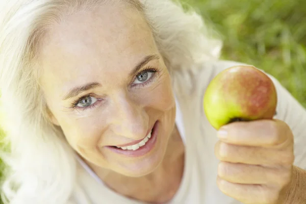 Äldre kvinna äta äpple — Stockfoto