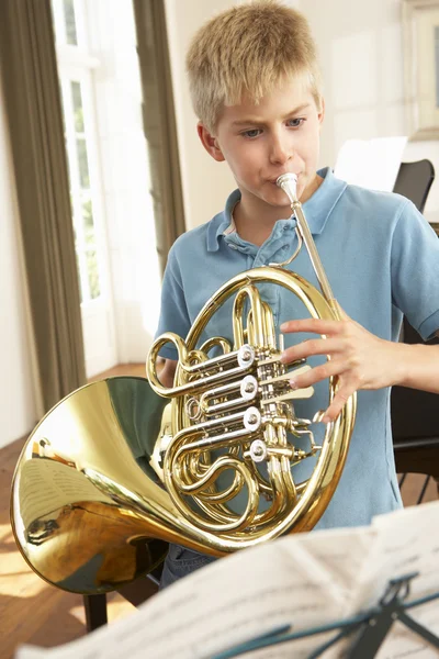 Menino tocando chifre francês — Fotografia de Stock