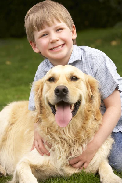 Ung pojke med golden retriever — Stockfoto