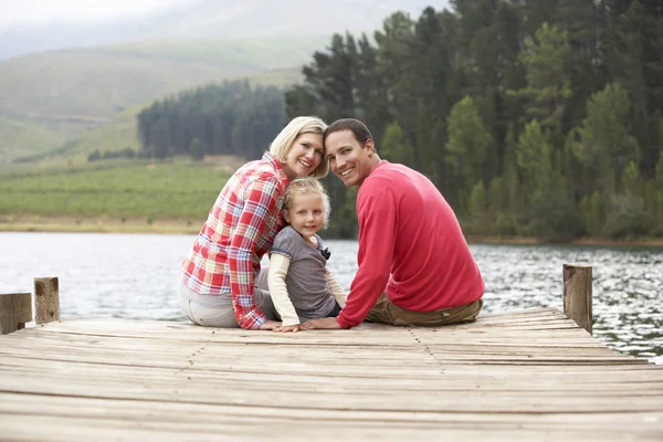 Familj sittande på en brygga — Stockfoto