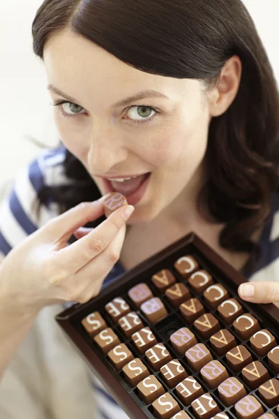 Woman eating chocolates — Stock Photo, Image