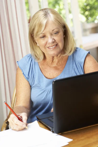 Senior kvinna som arbetar på hemmakontoret — Stockfoto