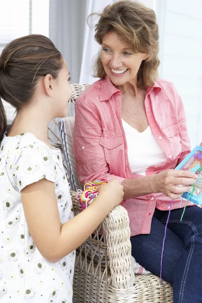 Vrouw en kleindochter doen cross stitch — Stockfoto