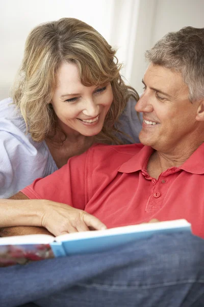 Mediados de edad pareja lectura libro — Foto de Stock