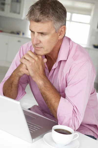 Человек среднего возраста работает на ноутбуке — стоковое фото