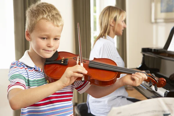 Young boy playing violin accompanied by teacher — Stock Photo, Image