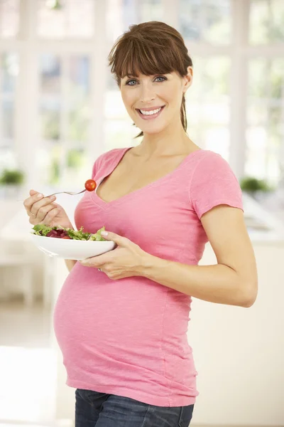 Mulher grávida comendo salada — Fotografia de Stock
