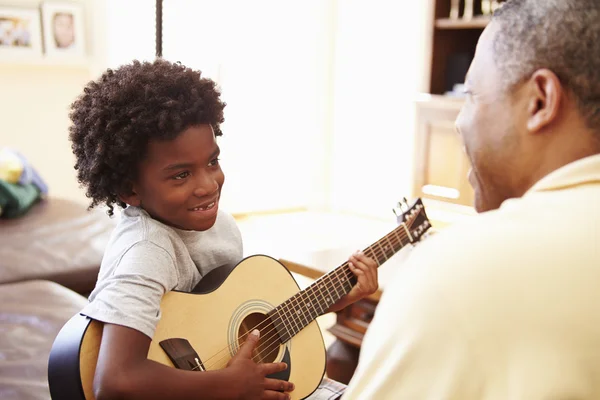Дедушка учил внука играть на гитаре — стоковое фото