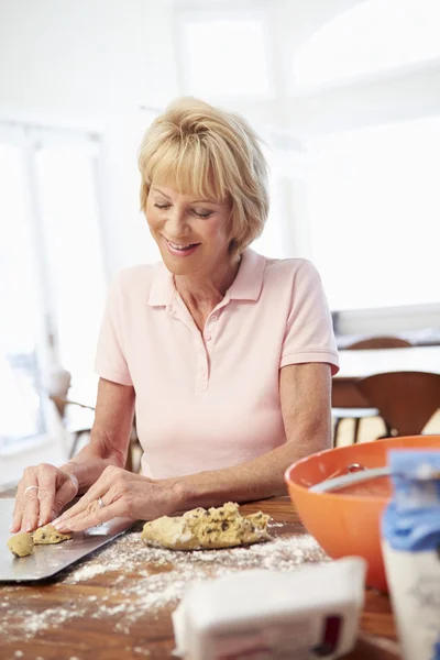 Старша жінка випікає печиво — стокове фото