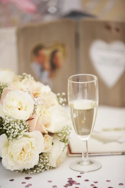 Brautstrauß und Glas Champagner am Hochzeitstag — Stockfoto