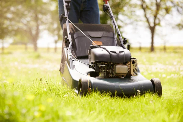 Mann arbeitet im Garten beim Rasenmähen — Stockfoto