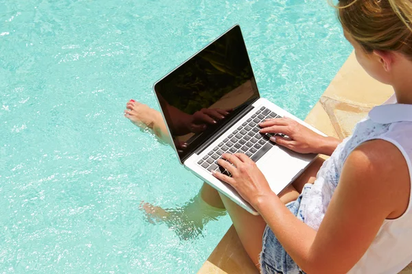 Mulher usando laptop na piscina — Fotografia de Stock