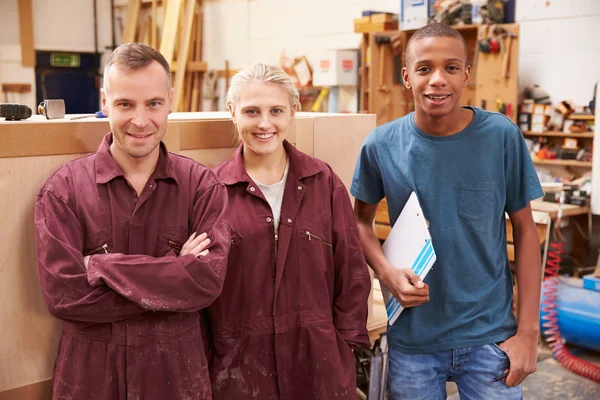 Carpintero con aprendices en taller de muebles — Foto de Stock