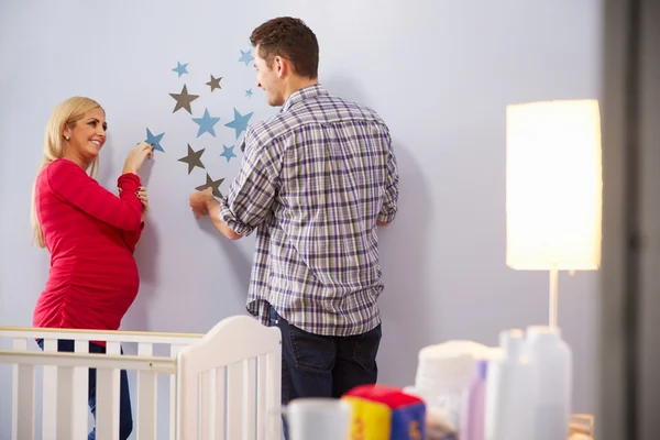 Couple ajoutant des décorations à la pépinière — Photo