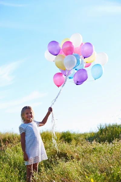 Chica joven sosteniendo globos —  Fotos de Stock