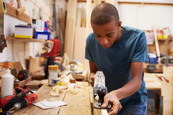 Apprenti rabotage du bois en atelier — Photo