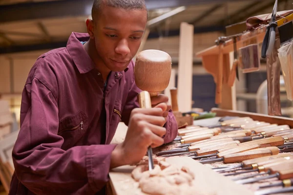 Lehrling schnitzt mit Meißel Holz — Stockfoto