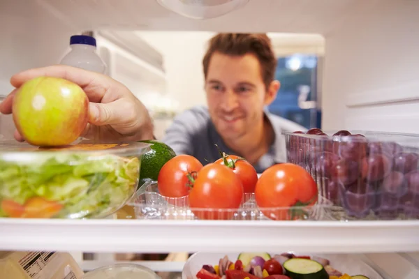 Uomo guardando dentro frigorifero — Foto Stock