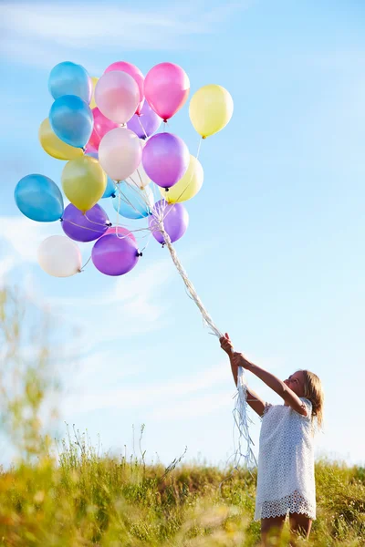 Chica joven sosteniendo globos —  Fotos de Stock