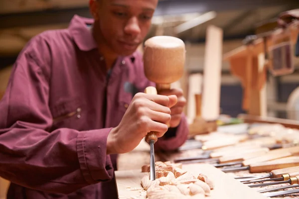 Aprendiz usando quisel para tallar madera —  Fotos de Stock