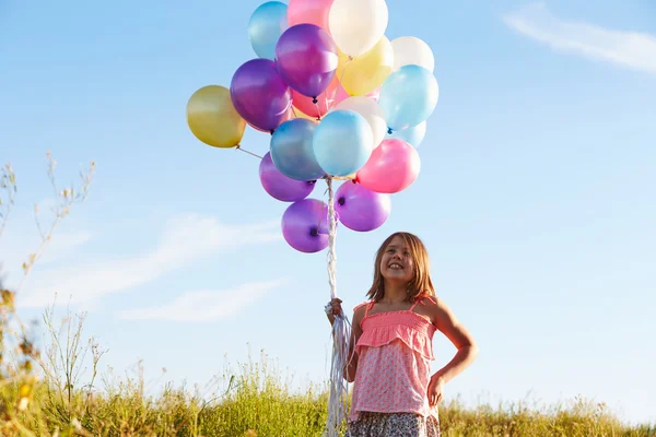 Chica joven sosteniendo globos —  Fotos de Stock