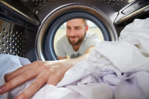 Man Doing Laundry Reaching Stock Photo