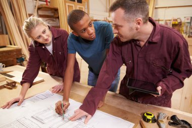 Carpenter With Apprentices  In Workshop clipart