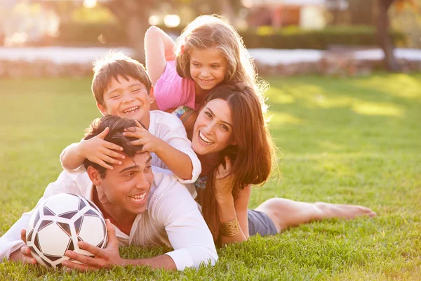 Familie liggen op gras samen — Stockfoto