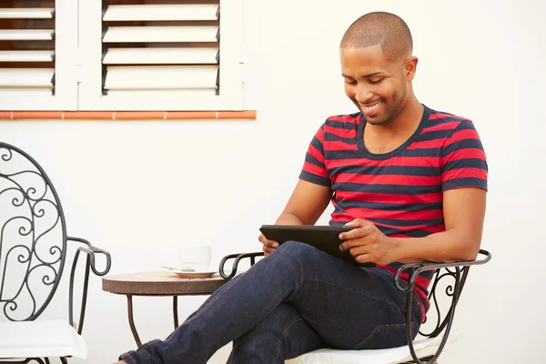 Muž sedí s digitálním tabletu — Stock fotografie