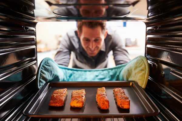 Uomo che prende filetti di salmone cotti — Foto Stock