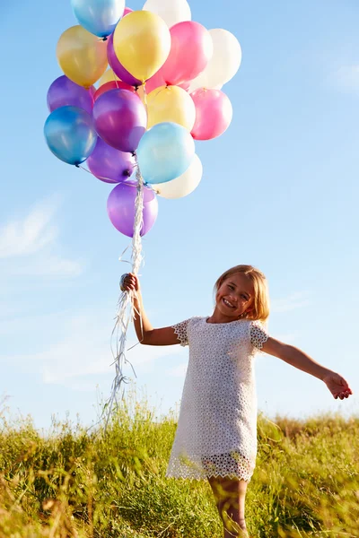 Ung flicka innehav ballonger — Stockfoto