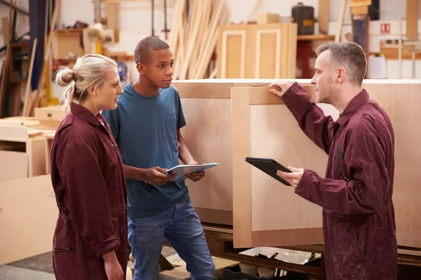 Carpintero con aprendices en taller de muebles — Foto de Stock