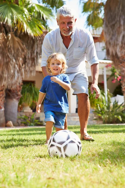 Grand-père jouant au football avec son petit-fils — Photo