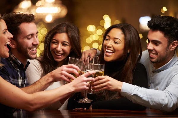 Grupo de amigos disfrutando de las bebidas en el bar — Foto de Stock