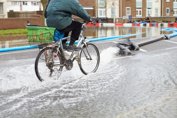 Велогонщик на затопленной городской дороге — стоковое фото