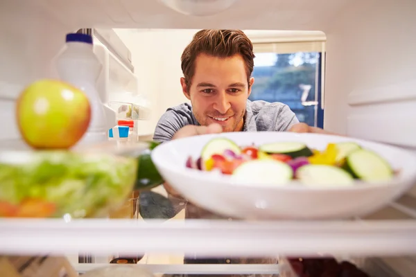 Hombre mirando dentro del refrigerador — Foto de Stock