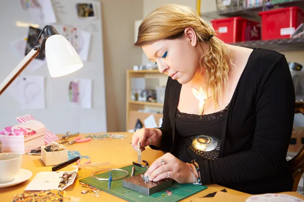 Jonge vrouw die sieraden maakt — Stockfoto