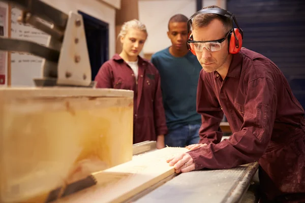 Charpentier avec apprentis utilisant une scie circulaire — Photo