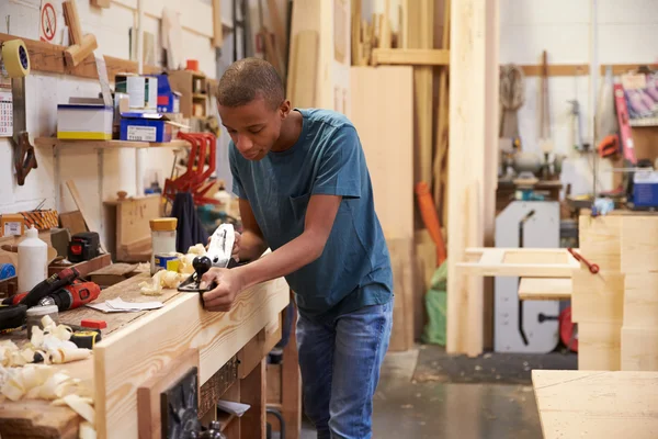 Apprentice Planing Wood In Workshop — Stock Photo, Image