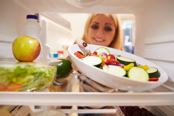 Mujer mirando dentro del refrigerador — Foto de Stock