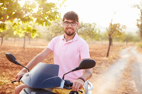 Joven hombre a caballo motor scooter — Foto de Stock