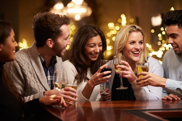 Grupo de amigos disfrutando de las bebidas en el bar — Foto de Stock