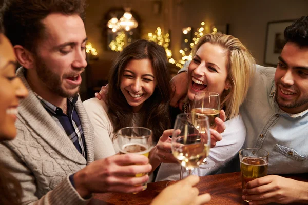 Grupo de amigos disfrutando de las bebidas en el bar — Foto de Stock