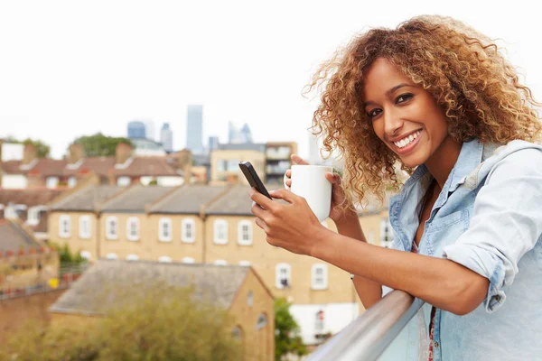 Kvinna med mobiltelefon på taket — Stockfoto