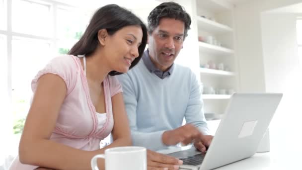 Pareja india usando ordenador portátil en la cocina — Vídeos de Stock